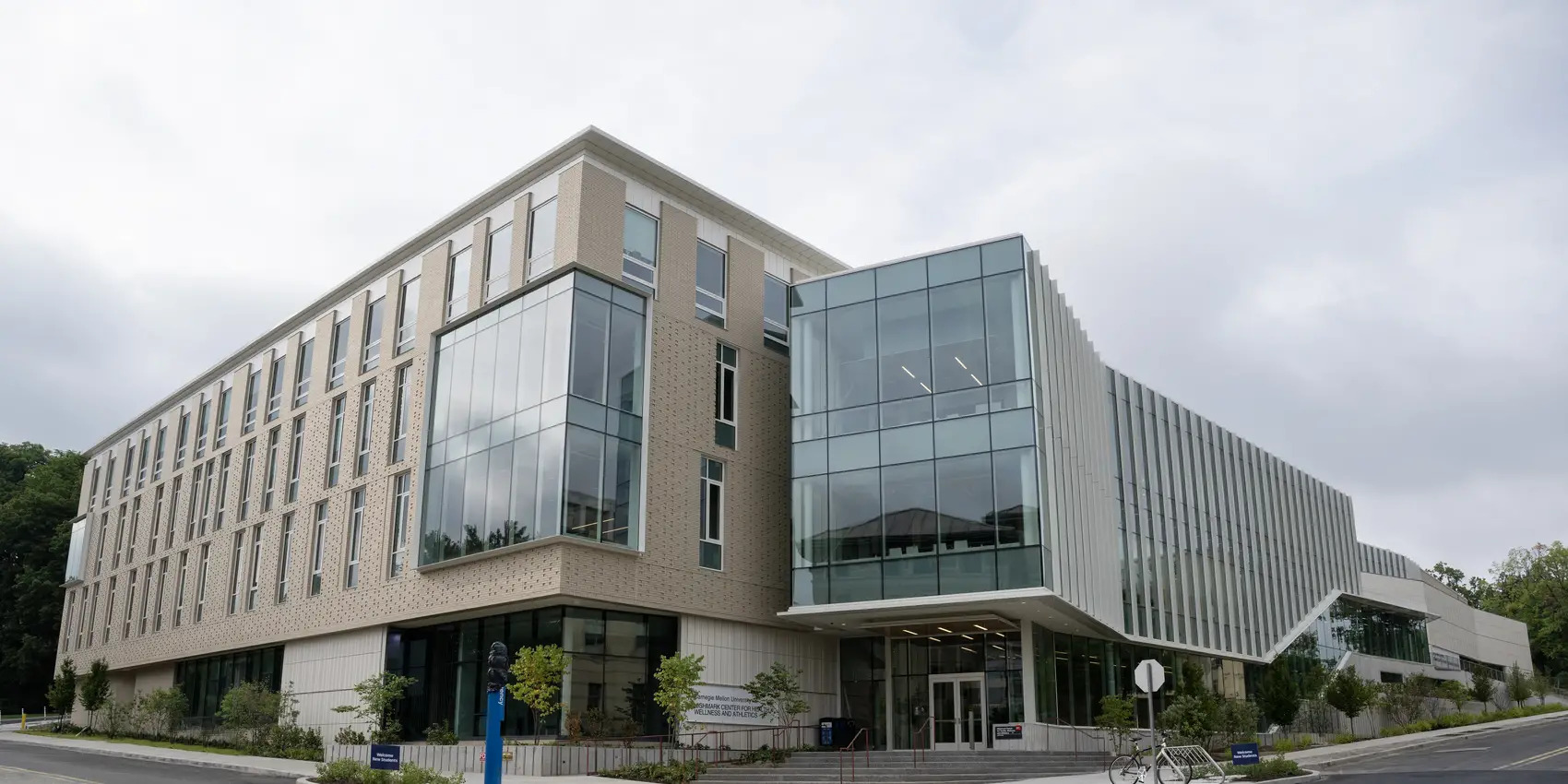Exterior view of the Highmark Center, a brick and glass building. The building is at an intersection, and there is a set of steps leading to the main entrance.